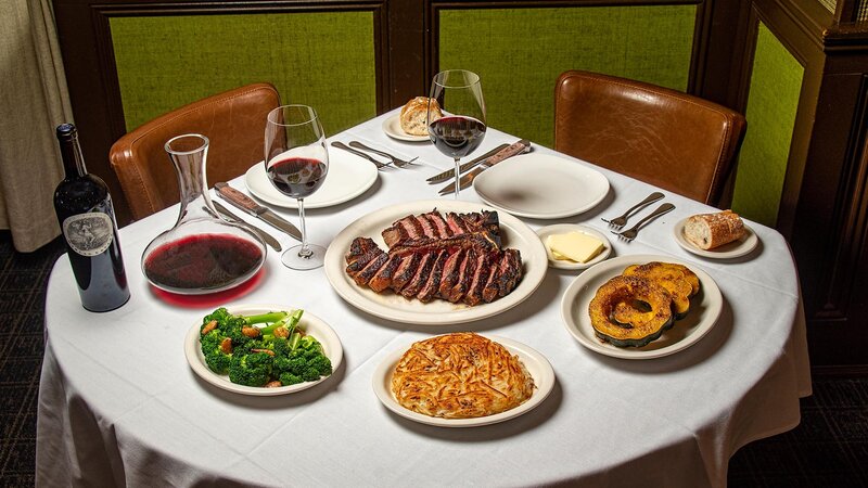 Table with wine, porterhouse, sauteed broccoli, hashbrown & acorn squash